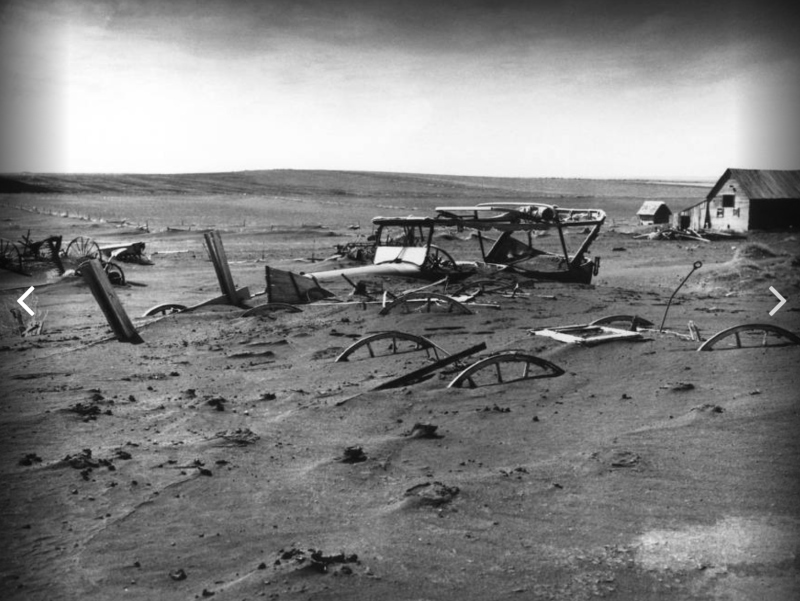 Farm machinery buried by a dust storm near a barn lot in Dallas, South Dakota, May 1936.   